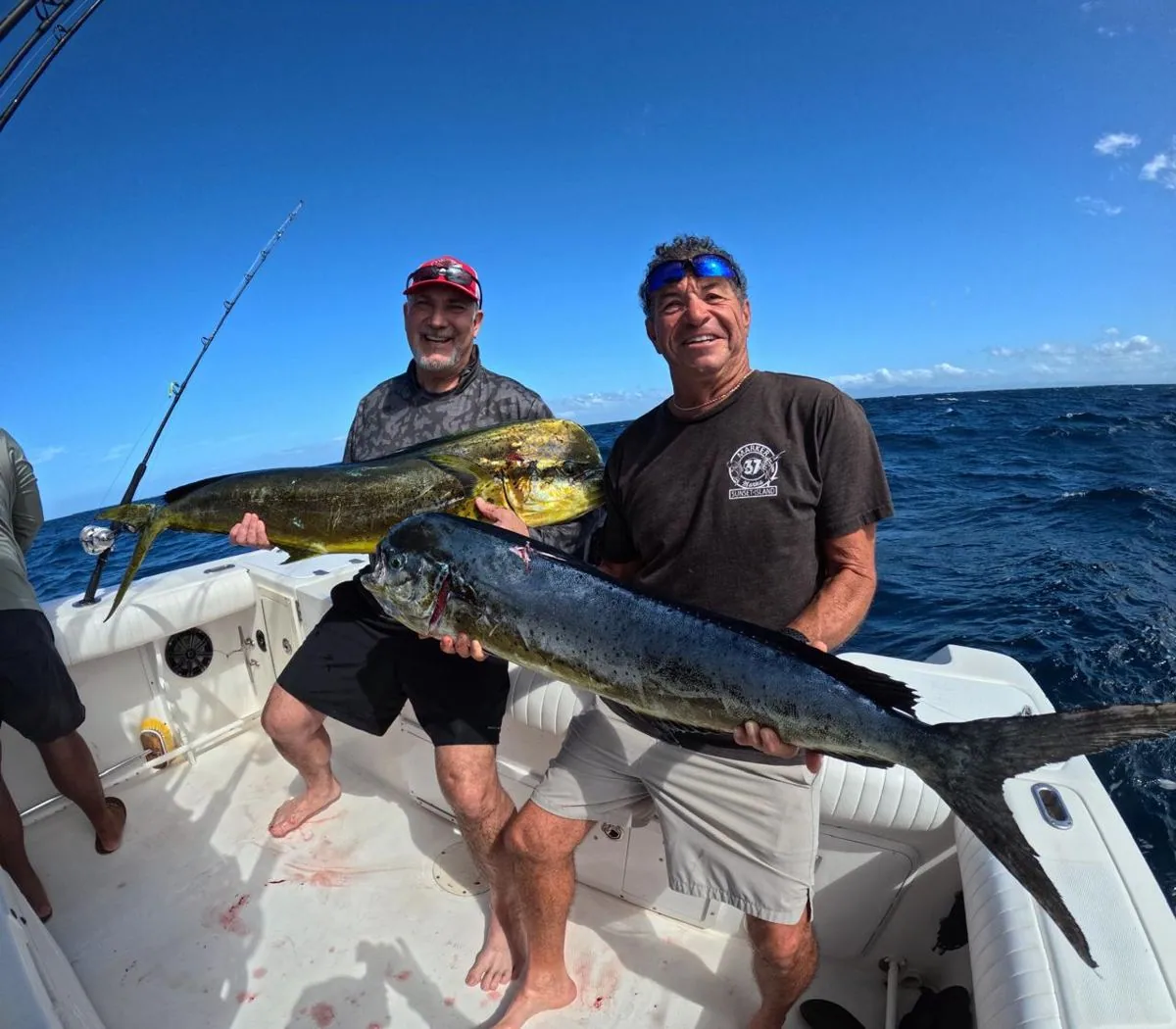 Two anglers holding mahi-mahi aboard a private fishing charter in Guanacaste
