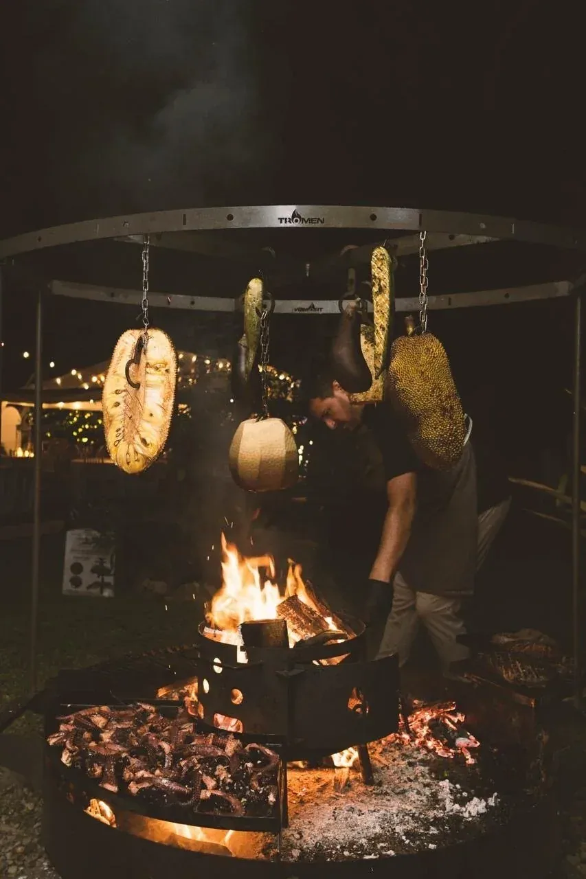 Nahui cooking over an open fire at night